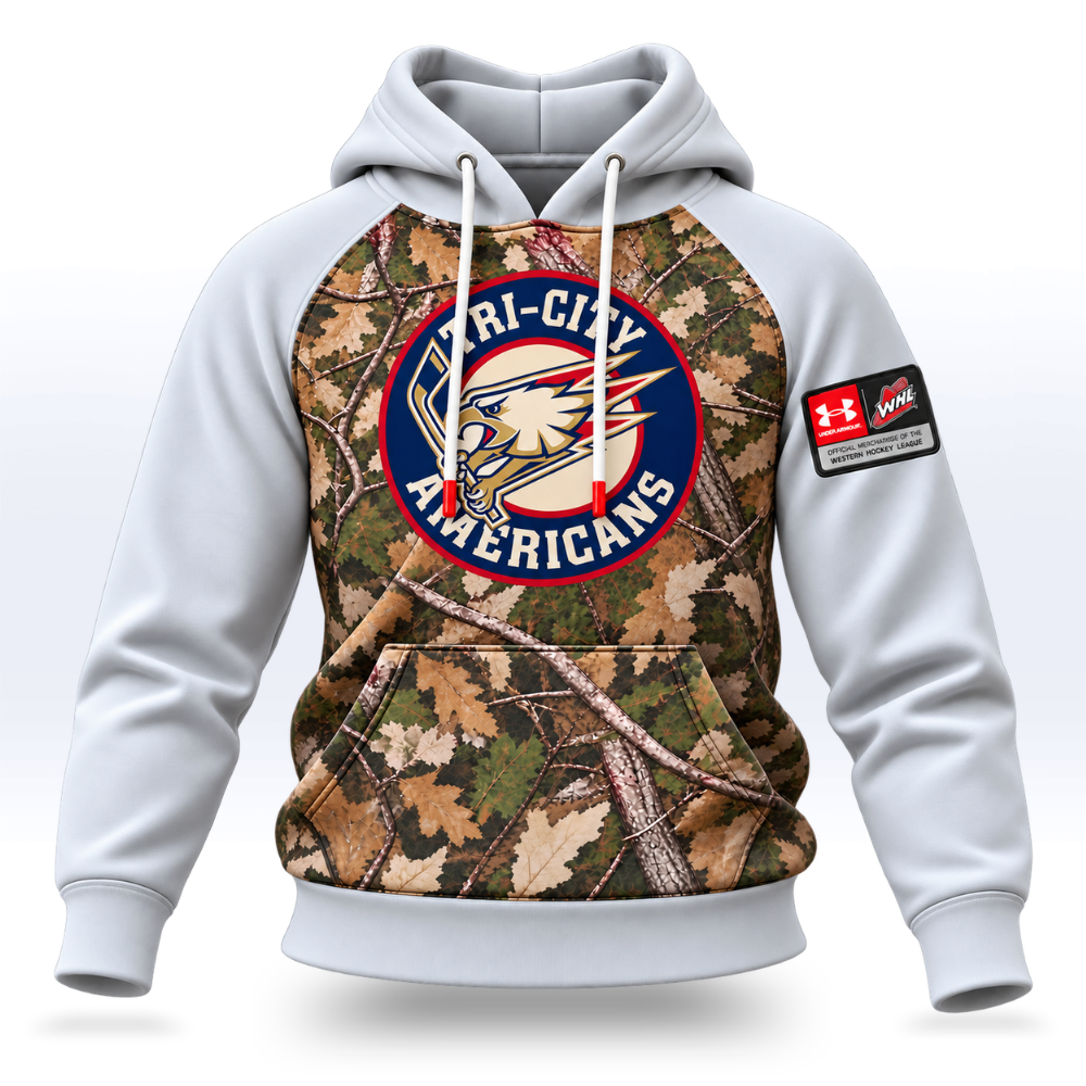 A white pullover hoodie with a large front graphic featuring a woodland camouflage pattern and a circular Tri-City Americans logo. A red and white Under Armour patch is printed on the right sleeve.